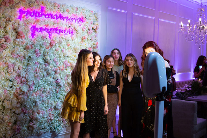 Group photo in front of a flower wall