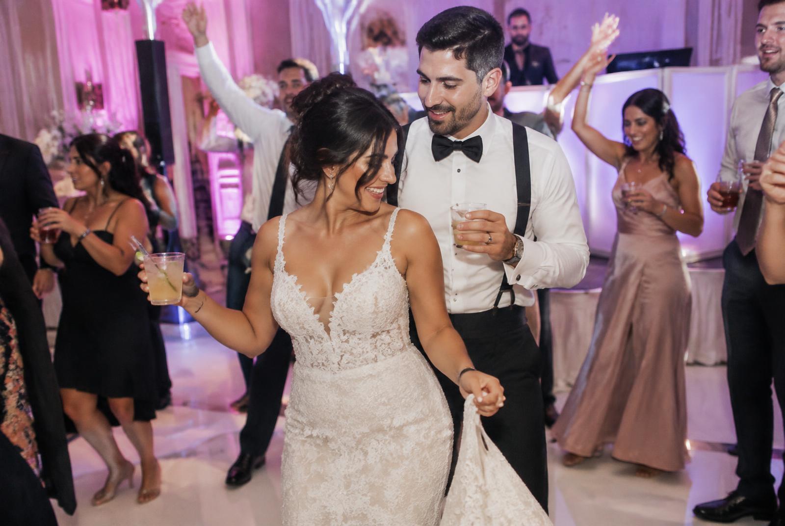 Packed dance floor with a DJ in the background